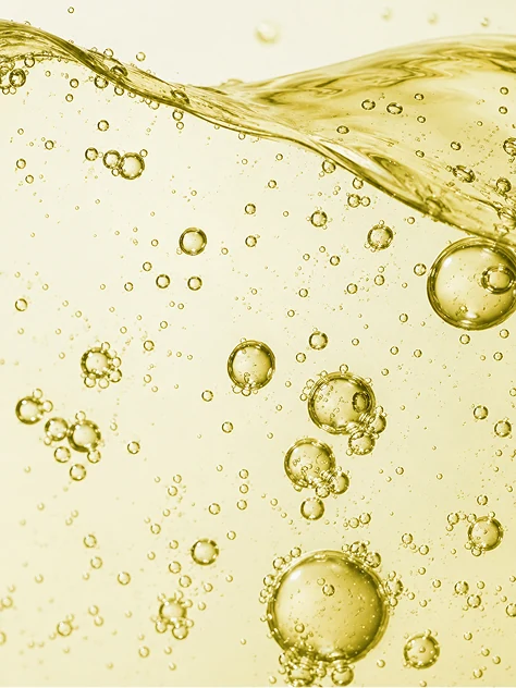 Bubbles rising through a golden fluid, lit from behind.